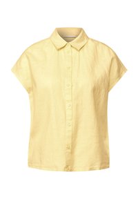 Camicia gialla a maniche corte con bottoni, realizzata in lino. Presenta un colletto classico e una finitura morbida e testurizzata. Chiusura frontale con bottoni e orlo dritto.