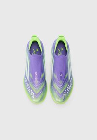 Lilla og neongrønn treningssko med slip-on design, med en teksturert overflate og dynamiske mønstre, merket "F50" på sidene.