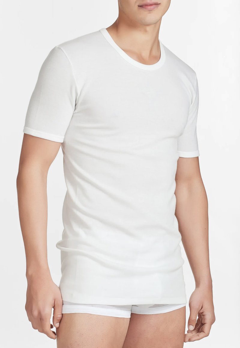 T-shirt bianco a maniche corte con scollo tondo e bordo a contrasto, abbinato a biancheria intima bianca. Texture liscia, design aderente.