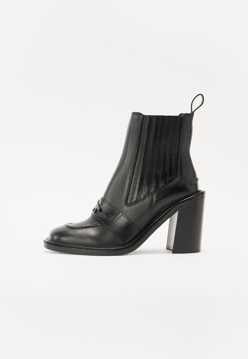 Black leather ankle boot with a high block heel, elastic side panels, and decorative stitching on the toe, featuring a pull tab at the back.