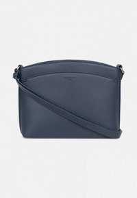 Borsa a mano in pelle blu navy con texture a granuli, parte superiore curva e una lunga tracolla regolabile. Presenta un design minimalista e una marchiatura discreta.