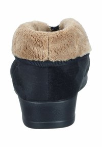 Schwarze Hausschuhe mit plüschigem beigem Kragen. Besitzen einen weichen Stoff, runde Form und strukturiere Sohle. Die Rückansicht hebt das gemütliche Futter hervor.