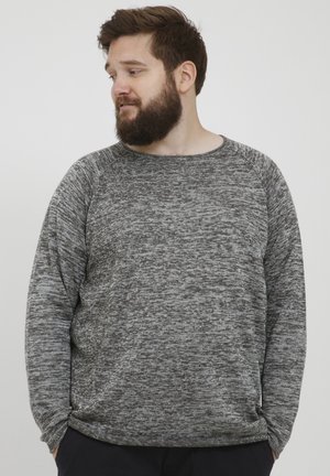 Suéter de tiro gris y negro con cuello redondo, mangas raglán largas y un corte relajado. Textura suave y diseño minimalista.