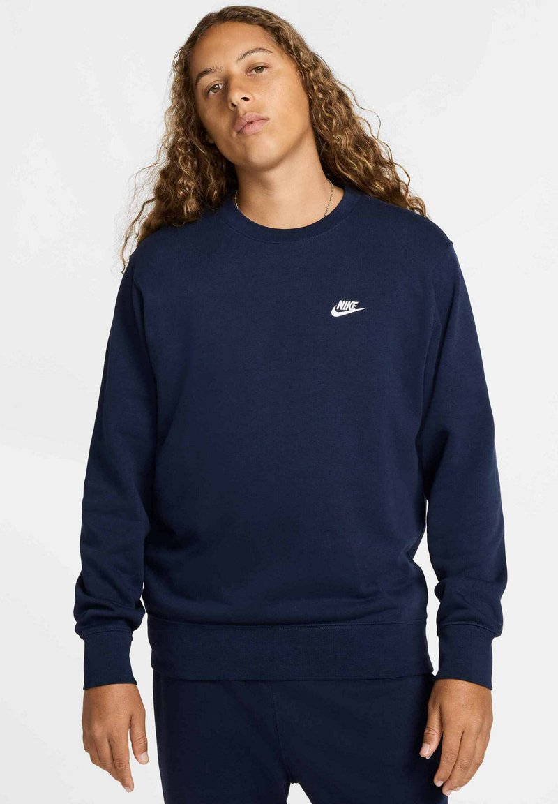 Felpa blu navy realizzata in tessuto morbido, con collo rotondo e maniche lunghe, con il logo Nike bianco sul petto.