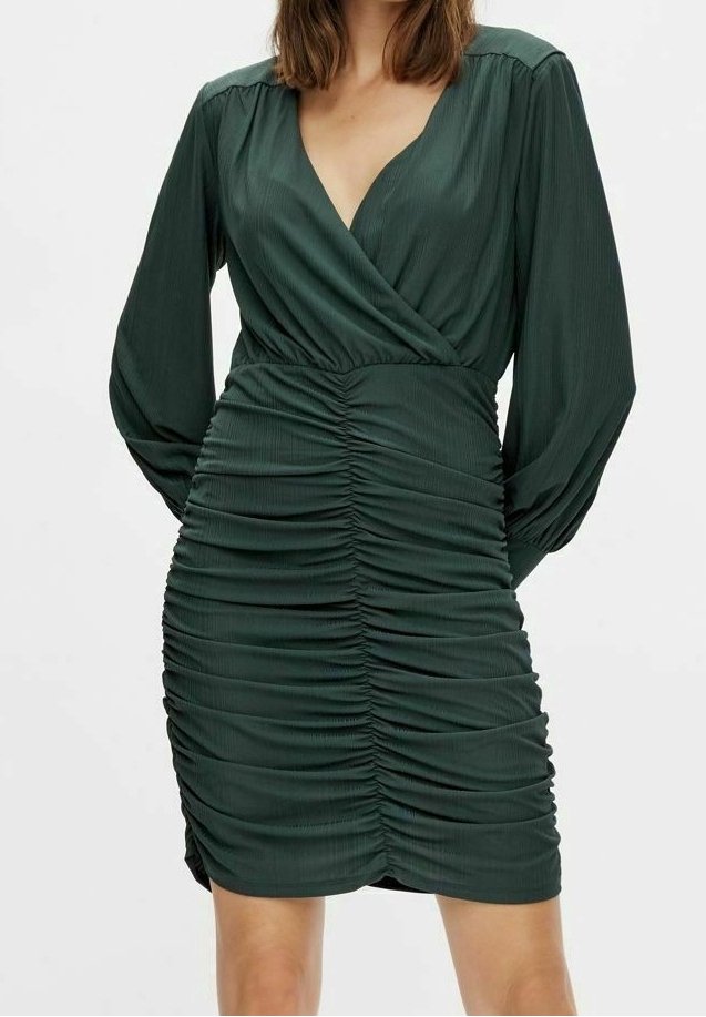 Robe portefeuille verte à manches longues avec décolleté en V, présentant des fronces gatherées sur les côtés et une coupe ajustée. Tissu texturé.