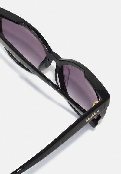 Gafas de sol negras con montura gruesa, lentes degradados en tonos púrpuras y detalles en dorado en las patillas que presentan el logo de MaxMara.