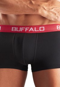 Melni bokseršorti ar sarkanu elastīgu jostasvietu, kurā ir balti uzraksti "BUFFALO". Gluda auduma un pieguļošs dizains.