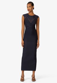 Navyblaues Kleid mit taillierter Silhouette, kurzen Ärmeln und schichtartigen Tüll-Bodice-Details. Verfügt über einen hohen Schlitz und einen glatten Stoff. 