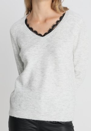 Maglione grigio chiaro con scollo a V e bordi in pizzo nero all'collo. Texture morbida, maniche lunghe e silhouette aderente.