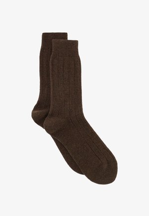 Calze a coste marroni realizzate in tessuto morbido, con lunghezza fino a metà polpaccio e punta e tallone rinforzati per una maggiore durata.