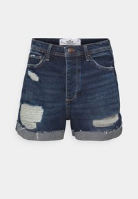 Tumman siniset farkkushortsit, joissa on reikäiseksityt helmat, kulutuspisteet, viisi taskua ja napitus edessä.