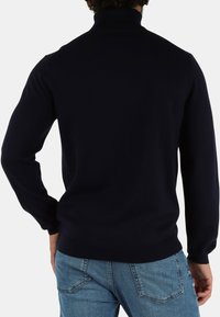 Maglione blu navy a collo alto in maglia con maniche lunghe, design aderente e dettagli a costine al colletto e all'orlo. La parte anteriore non è visibile.