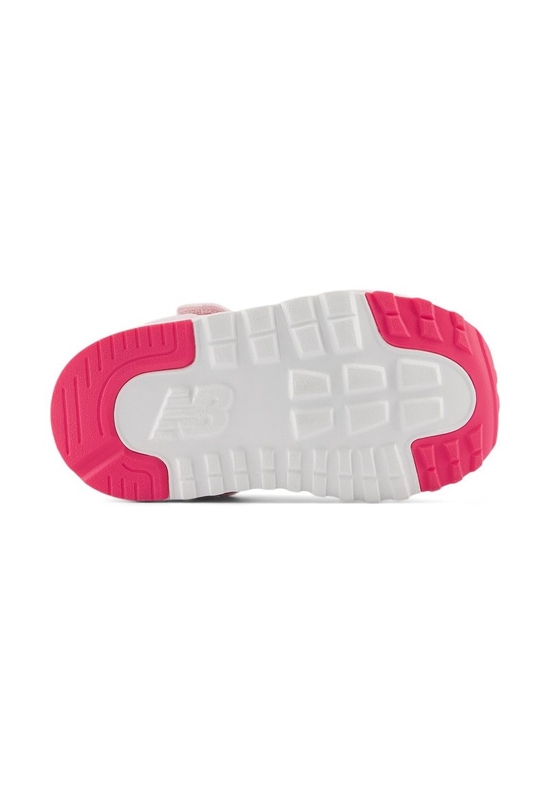 La semelle de la sneaker New Balance présente une base blanche avec une semelle en caoutchouc rose. Modèle texturé pour une meilleure adhérence, avec le logo embossé sur le côté.