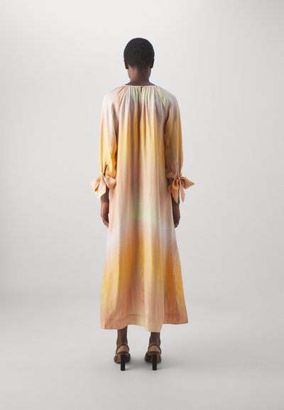Robe longue et fluide aux couleurs pastel, présentant un dégradé d'orange, de jaune et de vert. Elle a des manches bouffantes avec des nœuds aux poignets.