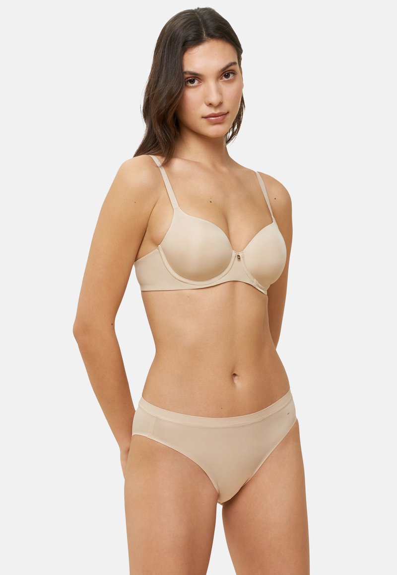 Conjunto de sujetador color beige y bragas a juego, textura suave, brillo sutil, soporte con varilla, tirantes ajustables, diseño sin costuras, detalle de hardware mínimo.