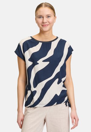 Blusa blu navy e crema con motivo astratto a onde, maniche corte, scollatura tonda e lacci regolabili in vita.