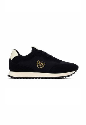 Zapatilla de running negra y blanca con cordones negros, suela blanca y logotipo de corona de laurel dorada con el texto "XI Est. 2003" en el lateral.