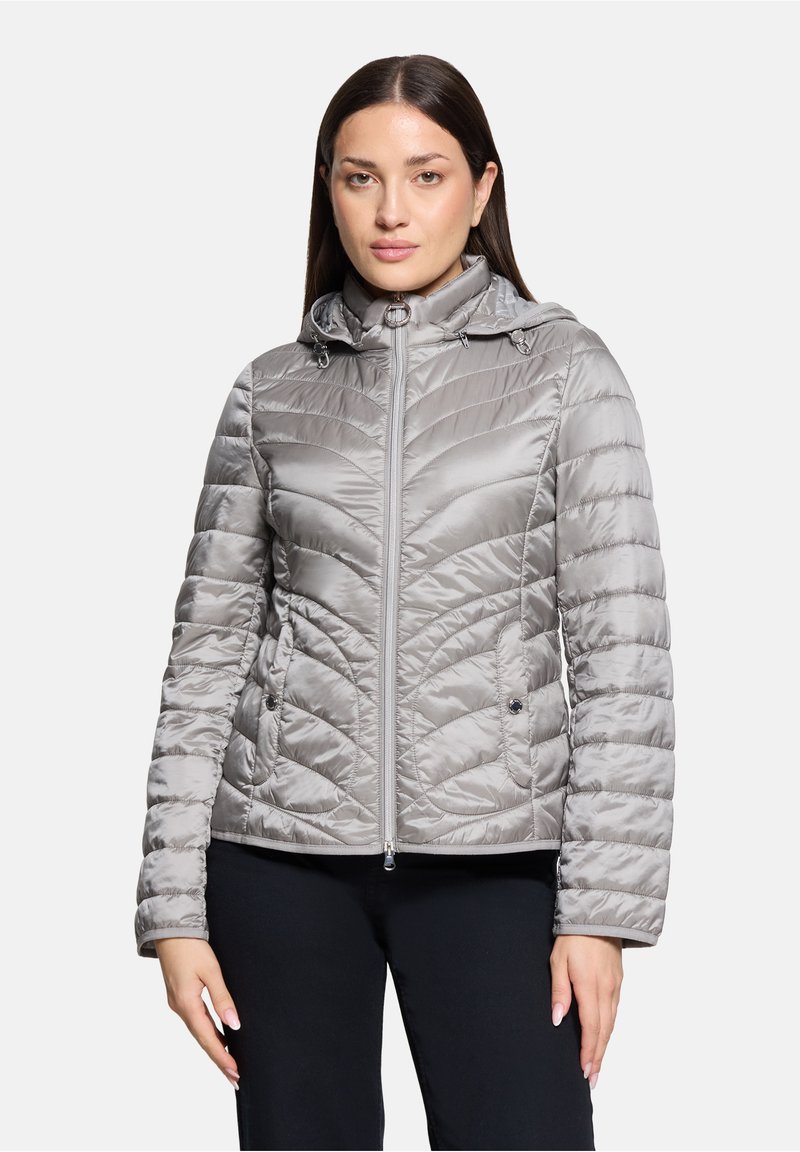 Veste matelassée grise avec capuche. Dotée d'une fermeture éclair et de motifs de couture diagonale. Tissu lisse et brillant avec poches latérales.