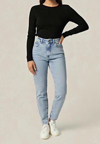 Musta pitkähihaisen paita pyöreällä pääntiellä, yhdistetty vaaleansinisiin korkeavyötäröisiin tiukkoihin farkkuihin ja valkoisiin lenkkitossuihin. Sileä kangas ja istuva malli.