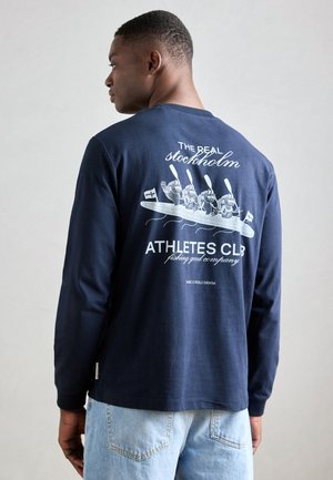 Navy long-sleeve shirt made of cotton, featuring a graphic print on the back with four characters in a boat, and text above and below them.