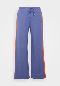 Blauwe wijde sweatpants met oranje zijkanten en een veterkoord tailleband, weergegeven tegen een witte achtergrond.