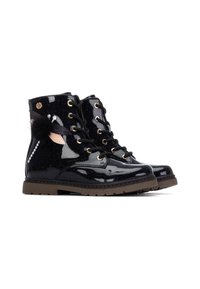 Botas de piel sintética negra con un acabado brillante, ojales dorados y cordones negros. Cuentan con un detalle de pelo sintético y suela de goma marrón.