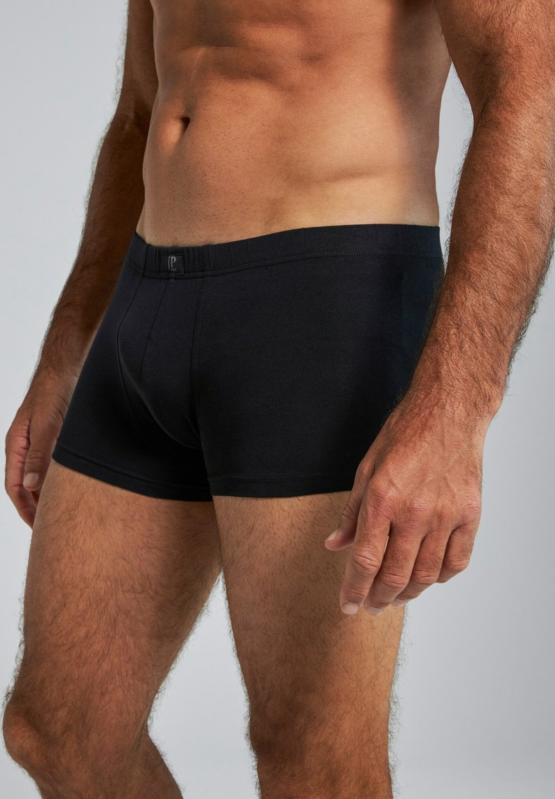 Boxers en coton noirs avec une coupe ajustée, dotés d'une ceinture douce et d'une texture lisse. Design minimaliste sans motifs ni accents.