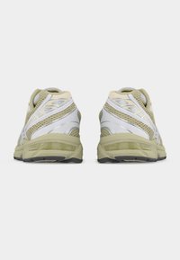 Ελαφριά αθλητικά παπούτσια για τρέξιμο, κυρίως γκρι με ασημένιες λεπτομέρειες, με διχτυωτό επάνω μέρος, μαλακή σόλα και υφασμένη φτέρνα για στήριξη.