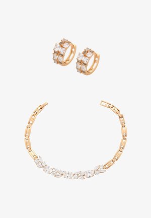 Goldene Creolen mit quadratischen und runden klaren Edelsteinen, kombiniert mit einem goldenen Gliederarmband mit ovalen und runden klaren Edelsteinen.