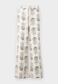 Pantalones de pierna ancha en tela crema con un patrón negro de flores y hojas. Cintura elástica con detalle de cordón. Textura suave.