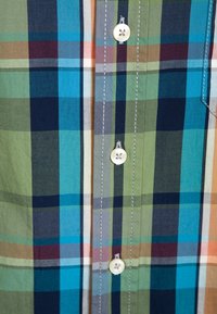 Korte mouwen gebloemd shirt met blauwe, groene en bruine tinten, met een button-down kraag en een witte knoopdetail bij de placket.