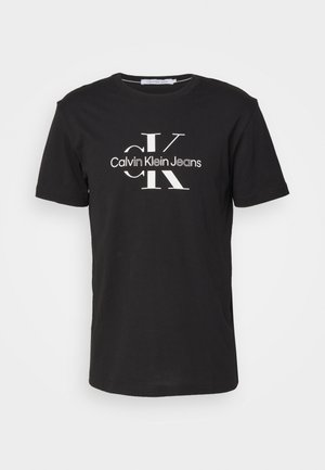 Sort kortærmet T-shirt med rund halsudskæring, med hvid Calvin Klein Jeans logo og store overlappende "CK" bogstaver foran.