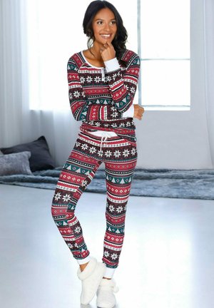 Red and green patterned pajama set with a snowflake design, featuring a fitted top and snug pants, complemented by white trim and soft slippers.