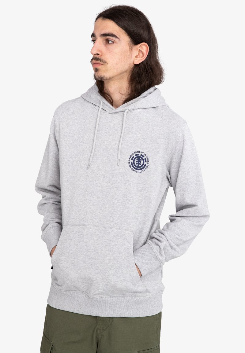Sudadera gris claro con un bolsillo frontal, capucha con cordón y un logo circular en azul marino en el pecho. Presenta puños y dobladillo acanalados.
