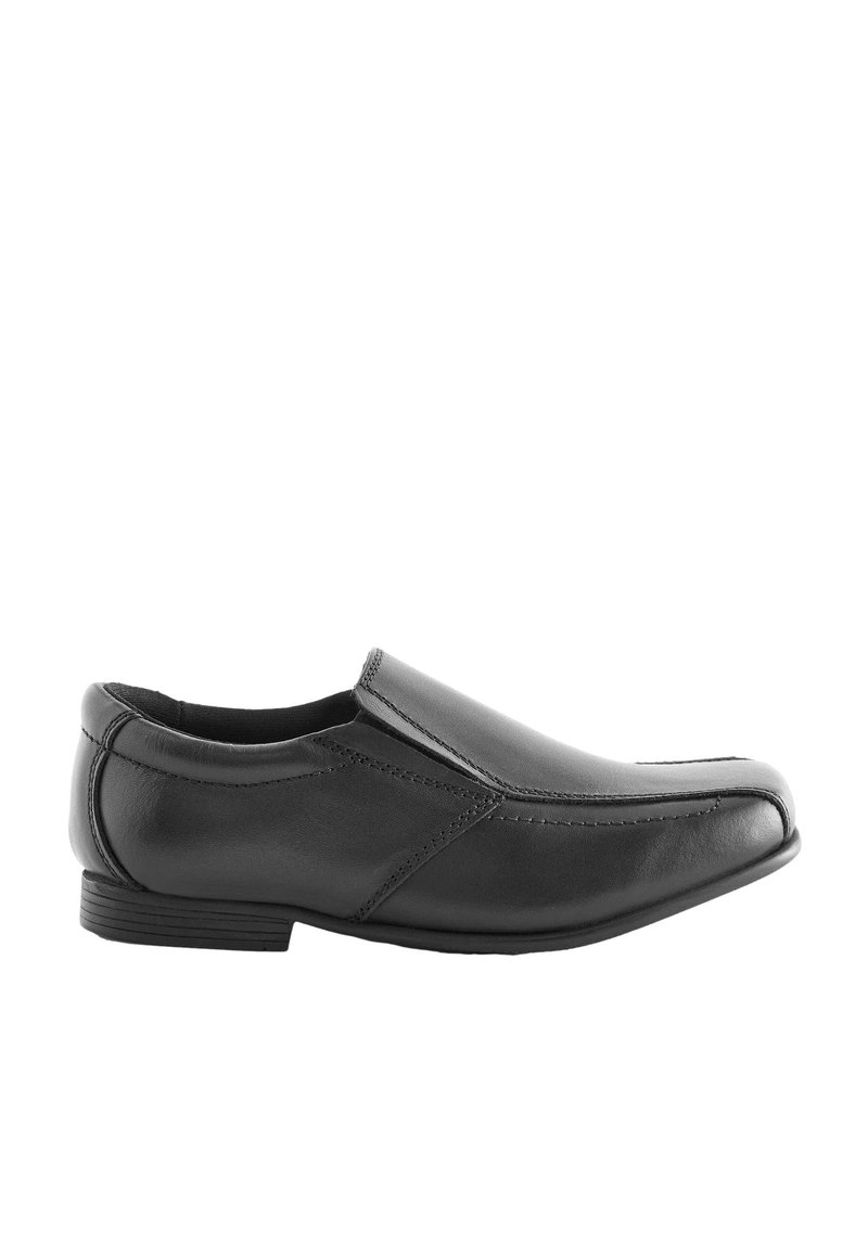 Zapato negro de cuero sin cordones con punta afilada, detalles de costura y tacón bajo. Presenta un acabado liso y un diseño minimalista.