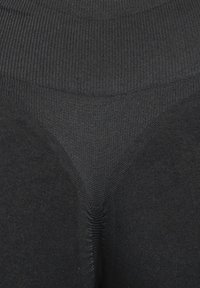 Svarta stretchiga leggings med en bred ribbad midjerem, avsmalnande ben och ett slätt texturerat tyg. Har en figursydd design med konturerande sömmar.