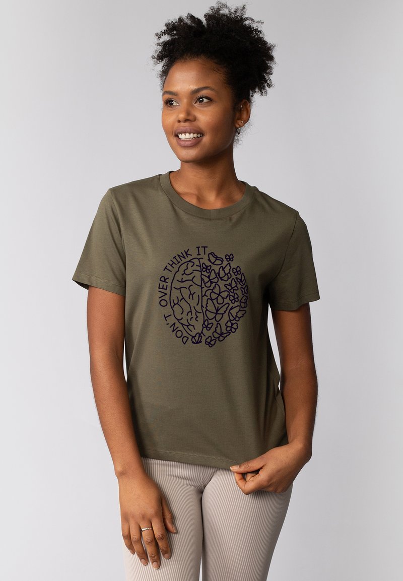 Olivgrünes Baumwoll-T-Shirt mit Rundhalsausschnitt, das ein kontrastierendes dunkelviolettes Grafikdesign eines Gehirns und floralen Motiven zeigt, der Text lautet "DENK NICHT ZU VIEL DARÜBER NACH".