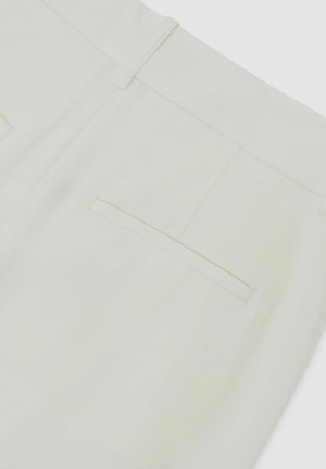 Pantaloni albi cu buzunar dublu la spate și bucle pentru curea, prezentați în prim-plan pe un fundal simplu.