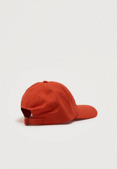 Red cotton cap with a curved brim, adjustable strap at the back, and visible stitching. The design features six ventilation holes.