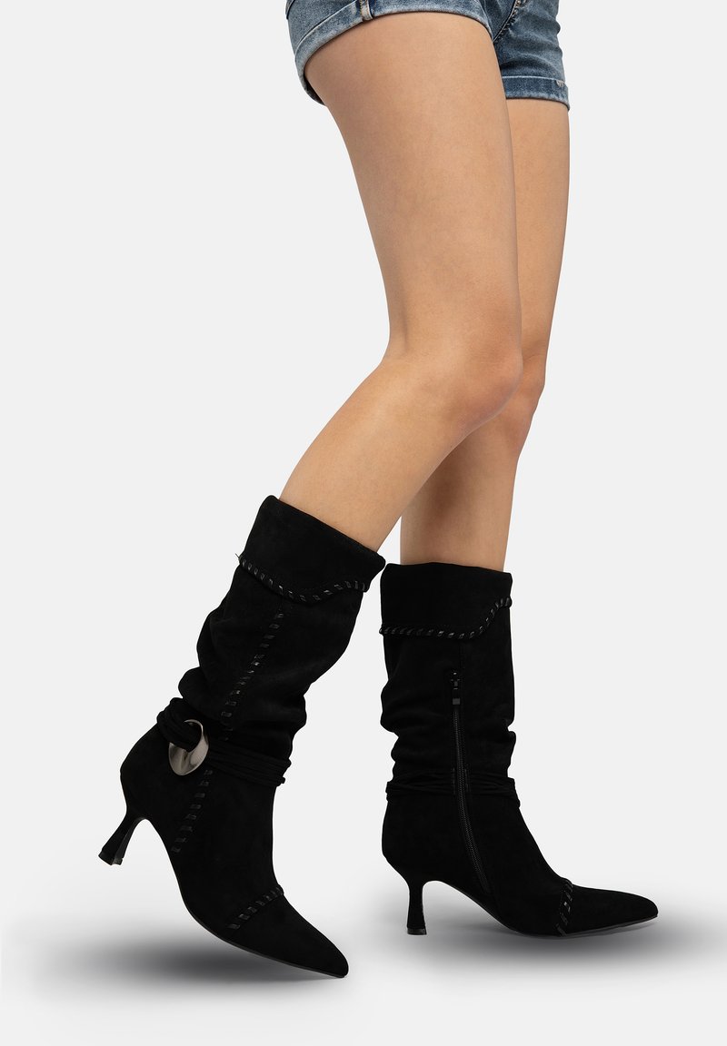 Schwarze Wildleder-Stiefeletten mit lockerem Design, spitzer Zehenpartie, Kittenabsatz, dekorativen Nähten und seitlichem Reißverschluss.