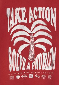 Rød t-shirt med hvid tekst, palmetræsgrafik og dekorative symboler. Teksten lyder "TAK HANDLING LØS ET PROBLEM" med zigzag-mønster på stammen.