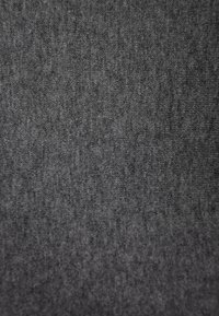 Tmavě šedá látka s měkkým, texturovaným povrchem, která vykazuje jemný vzor, vhodná pro oděvní nebo čalounické použití.