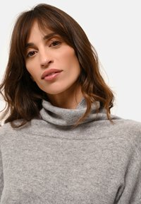 Harso kaula-aukko neule, joka on valmistettu pehmeästä kankaasta, tarjoaa rennon istuvuuden ja hienovaraisen rakenteen, korostaen kaulaa ja hartioita.