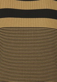 Haut en maille rayé présentant des rayures horizontales noires et dorées, avec une texture côtelée. Le motif alterne entre des rayures larges et étroites.