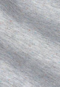 Lichtgrijze stof met een subtiele textuur en kleine gekleurde stippen in blauw, rood en geel doorheen, wat een casual patroon creëert.
