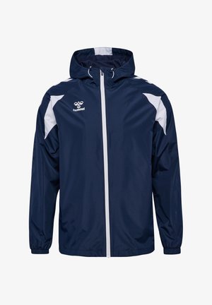 Marineblaue Kapuzen-Windjacke mit weißem Reißverschluss, weißen Schulterakzenten, elastischen Bündchen und einem weißen Hummel-Logo auf der Brust.