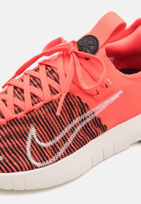 Sneaker in magenta e nero con tomaia in tessuto testurizzato, suola in gomma bianca, lacci fai-da-te e un accentuato logo laterale.