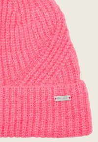 Heldroze gebreide beanie met ribgebreide rand en een klein rechthoekig metalen label met daarop de gravure "TOM TAILOR" op de rand.