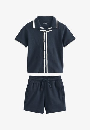 Marineblaues kurzärmeliges Hemd mit Knöpfen, weißem Besatz und passenden marineblauen Shorts mit Kordelzugbund und Taschen.