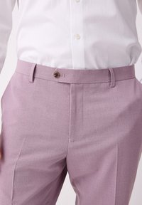 Jasnofioletowe spodnie wizytowe o gładkiej fakturze, z płaskim przodem, zapięciem na guzik i bocznymi kieszeniami, w połączeniu z białą koszulą.